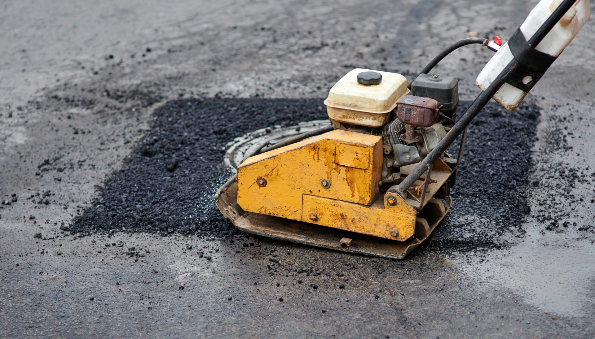 A small machine is used to perform asphalt repair in Salt Lake City, UT.